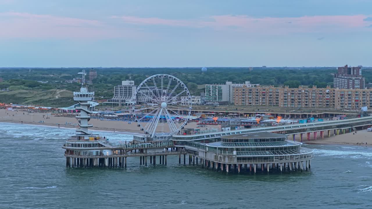 Solnedgangs-luftfoto af Scheveningen Pier med pariserhjul over glimtende hav, Holland