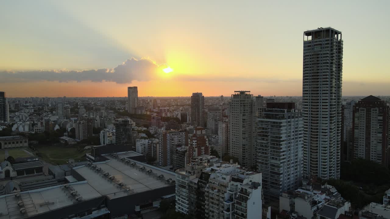 pan dejó volando sobre los edificios del barrio de palermo y el rascacielos al atardecer con el sol brillando detrás de las nubes, buenos aires, argentina