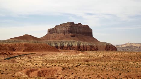 tilt up shot of a beautiful large red rock butte at the entrance of the utah goblin valley state park on a warm sunny summer day