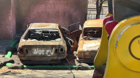 handheld long lens shot revealing two cars burned by the eaton fire in altadena, california. 4k