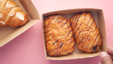 assortment of croissants and chocolate pastries in boxes