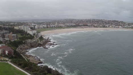 aerial: drone flying over mackenzies point towards bondi beach on a cloudy overcast day, in sydney australia