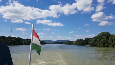 sailing with a boat on a river with fluffy clouds on a sunny summer day hungarian flag