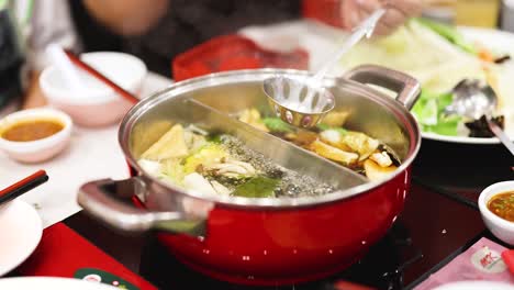 preparing hotpot with fresh ingredients and broth