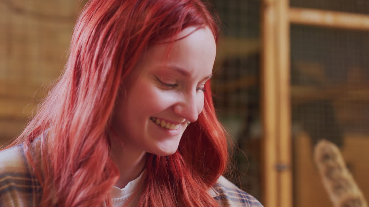 caucasian woman smiling in workshop, braided red hair, plaid shirt, metal mesh shelves, woodworking tools in background, warm sunlight, hands at work, genuine laughter, creative focus, friendly