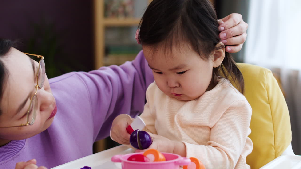 아시안 어머니 가 아기 와 함께 놀고 있다