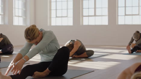 clase de yoga de una mujer madura sana practicando la pose de flexión hacia adelante de la cabeza a la rodilla disfrutando del entrenamiento físico matutino en el estudio
