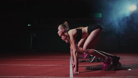 atletas femeninas calentándose en la pista de atletismo antes de una carrera. en cámara lenta