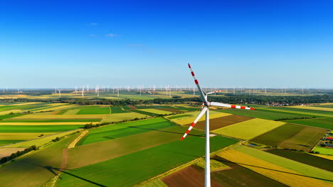 approaching rotating blades of the windmill. aerial perspective on the windfarms producing green energy.
