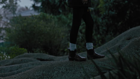 young woman hiking forest path walking on big tree roots wearing red boots exploring nature enjoying woodland journey