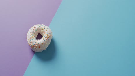 video of donut with icing on purple and blue background