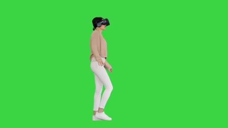 beautiful lady with brunette hair walking and using vr on a green screen, chroma key