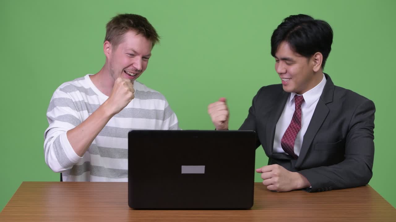 젊은 아시아 사업가와 젊은 스칸디나비아 사업가가 노트북으로 함께 일하고 있습니다.