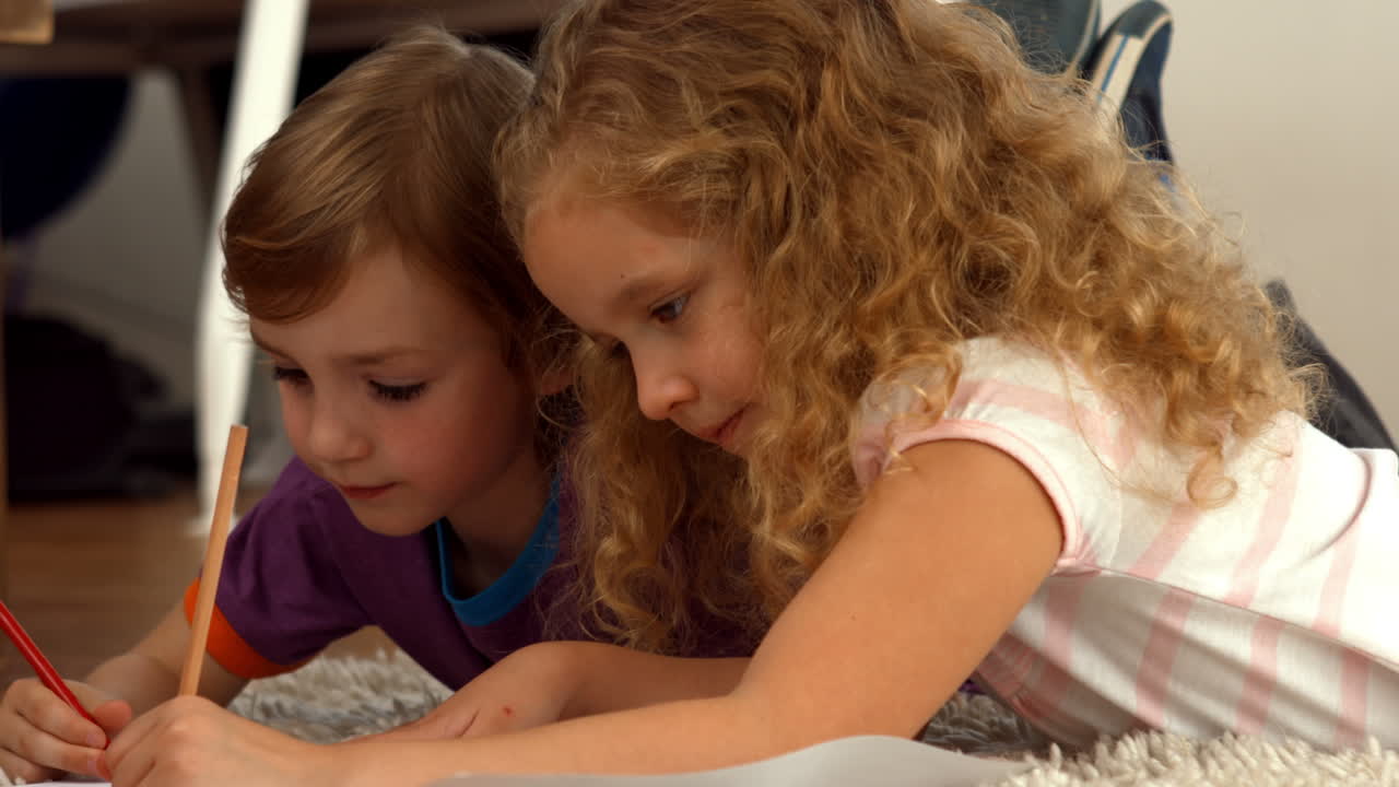 Cute siblings drawing on paper