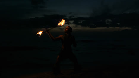 Fire-juggler-juggling-fire-sticks-in-the-beach-4k