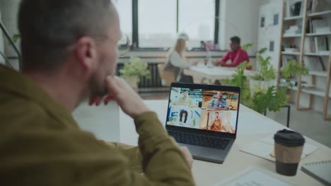 businessman video conferencing with colleagues at workplace in office