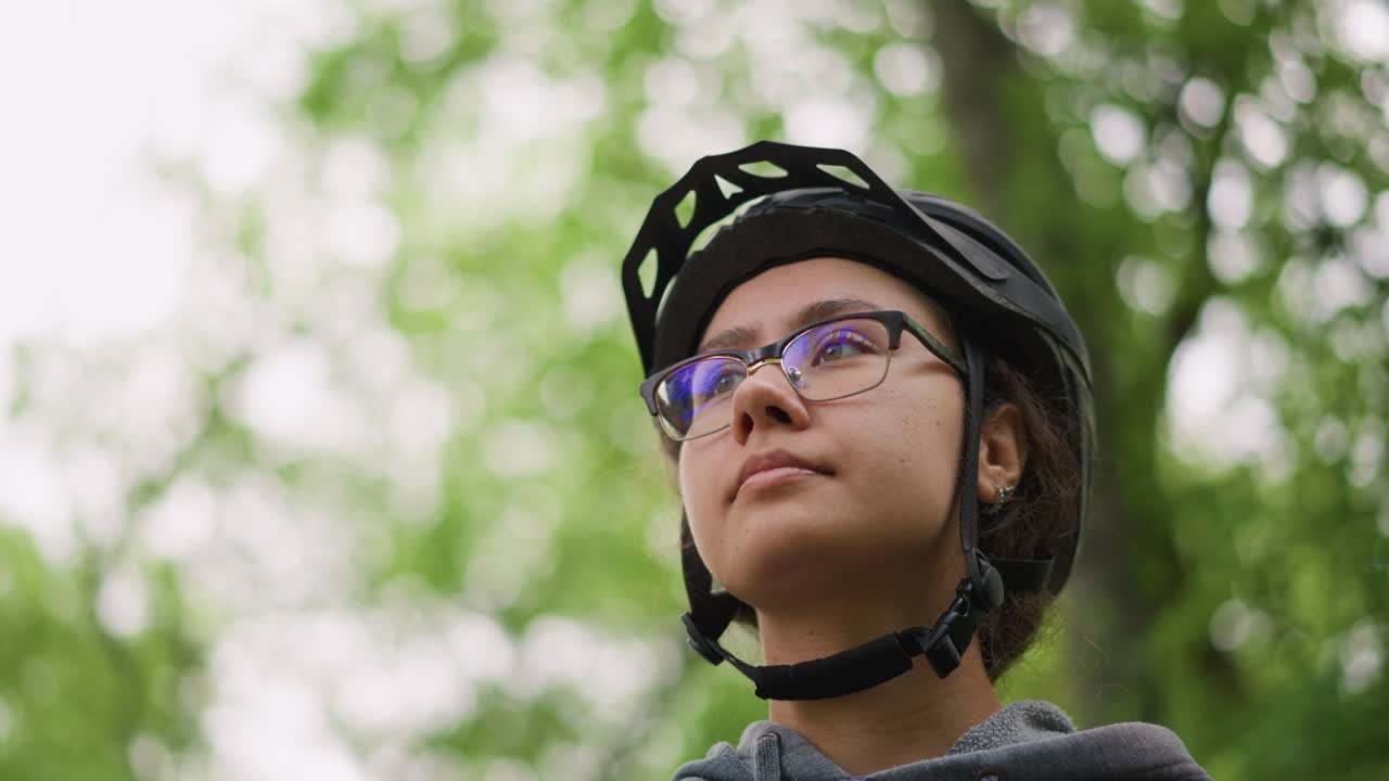 Cyclist In Calm Moment, Peaceful Rider Pauses In Nature, Asian Cyclist Displaying Contemplative Tranquility Outdoors, Cyclist In Serene Environment Reflecting Peacefully With Nature Background