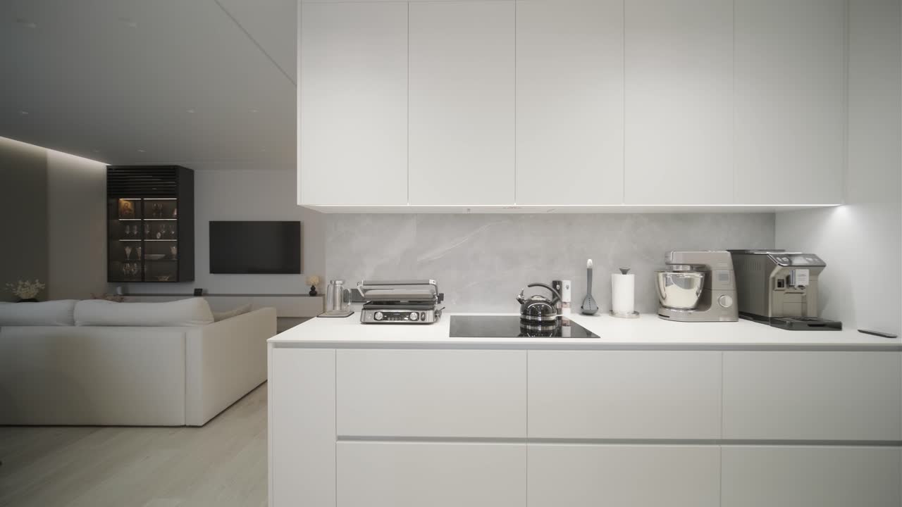 una lujosa cocina con una gran isla, un grifo de oro y una lámpara sputnik, electrodomésticos de acero inoxidable y encimeras de mármol blanco.