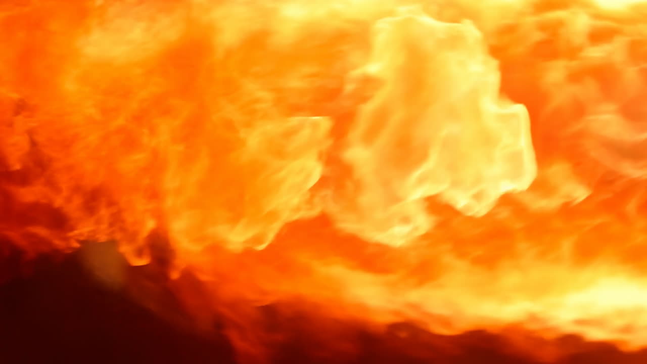 Buldrende orange flammer opsluger nærbillede af skovbrand, intens varme og hvirvlende røg, glødende gløder og aske