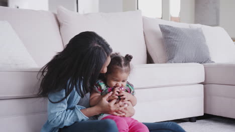 Mother-Sitting-On-Floor-And-Playing-With-Baby-Daughter-At-Home