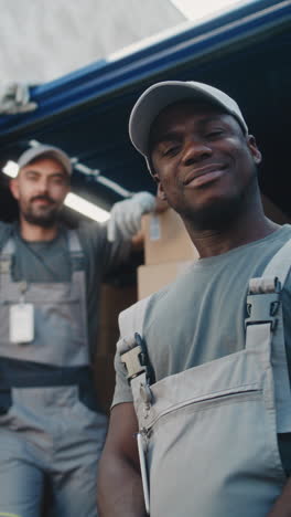 smiling delivery workers with boxes in a van