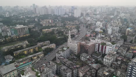 aerial circling timelapse of mosque minaret in urban city with highway flyover