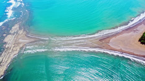 Aerial-drone-footage-revealing-a-beach-shaped-like-a-whale's-tail-in-Ballena-Marine-National-Park,-Costa-Rica-,-Manuel-Antonio