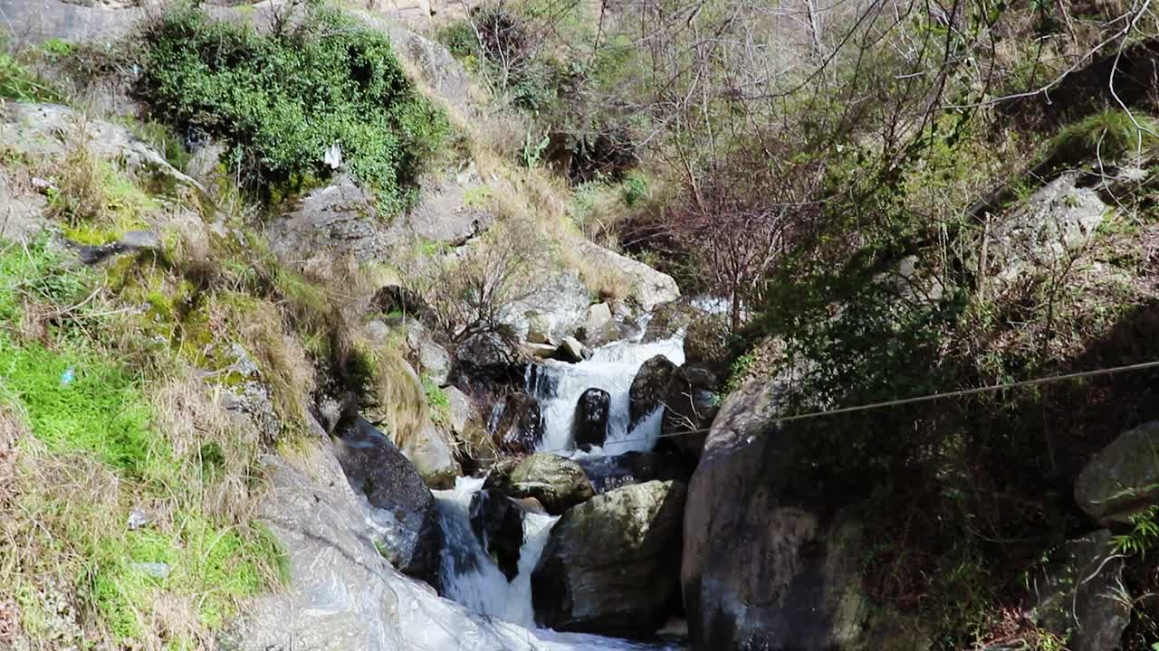 cascada que fluye de la montaña en el día desde un ángulo plano