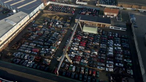 wide aerial overview of junkyard filled with wrecked cars