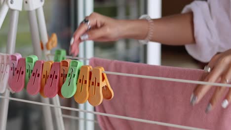 person hanging laundry with colorful clothespins