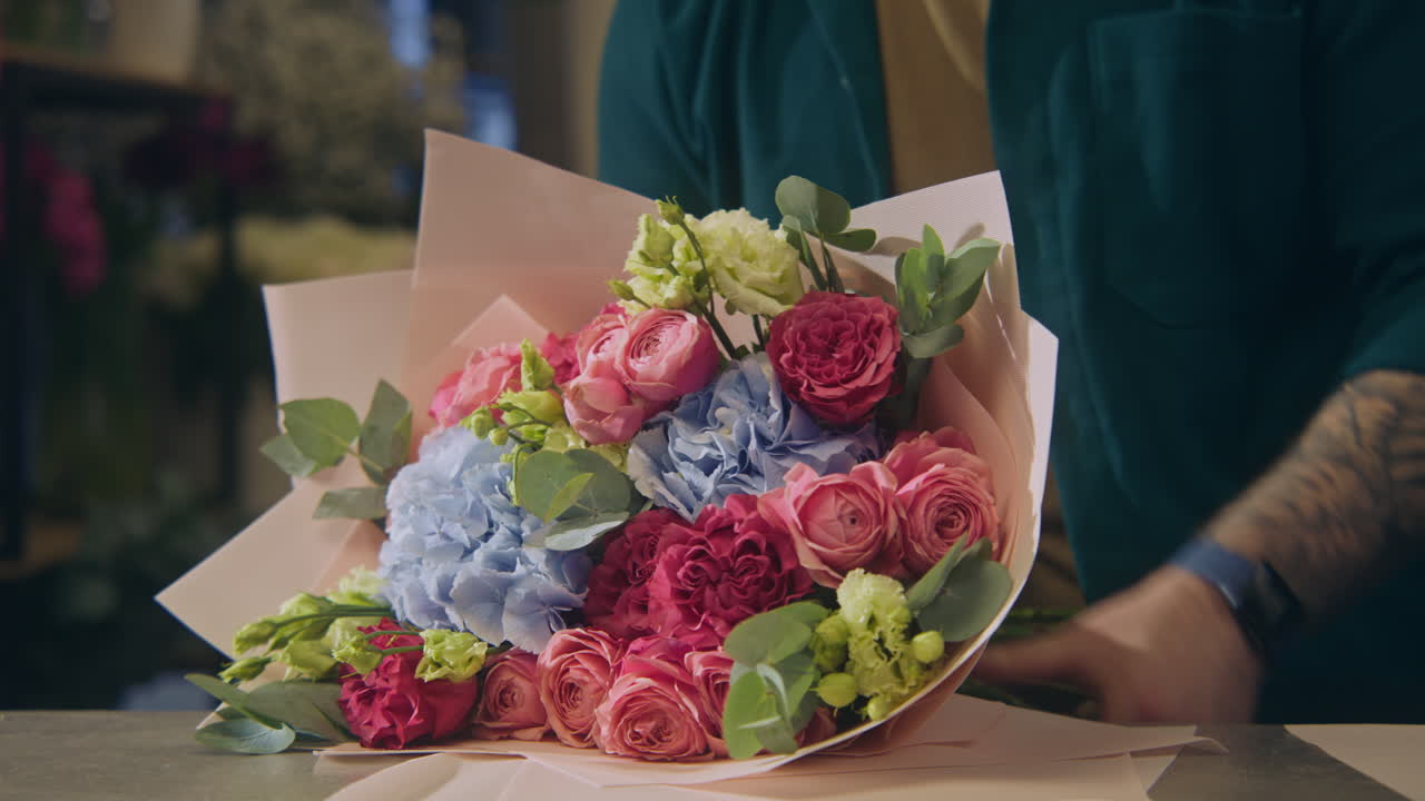 концентрированный мужской цветочник обертывает цветы букетом