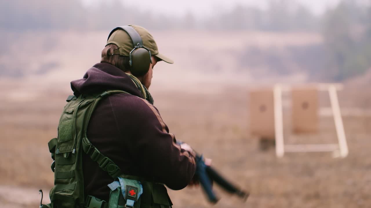 un cazador con auriculares dispara un arma 3