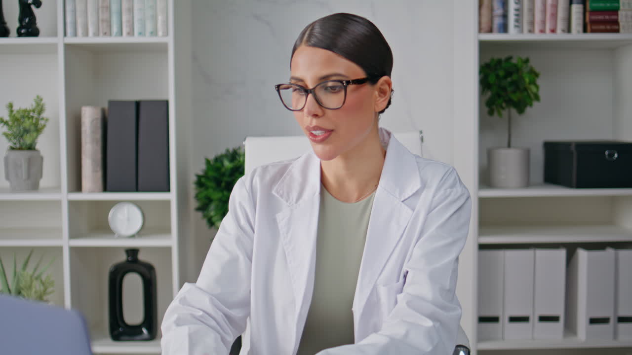 Medic greeting online consultation looking laptop screen in clinic closeup
