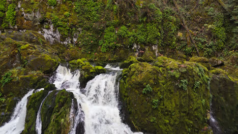 stunning 4k drone footage of waterfall with moss covered rocks in forest