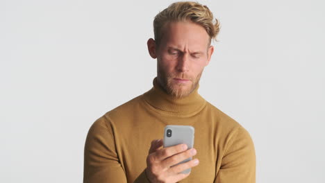 Serious man chatting with smartphone