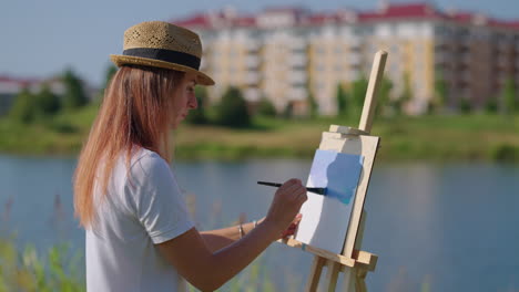 woman painting outdoors by a lake