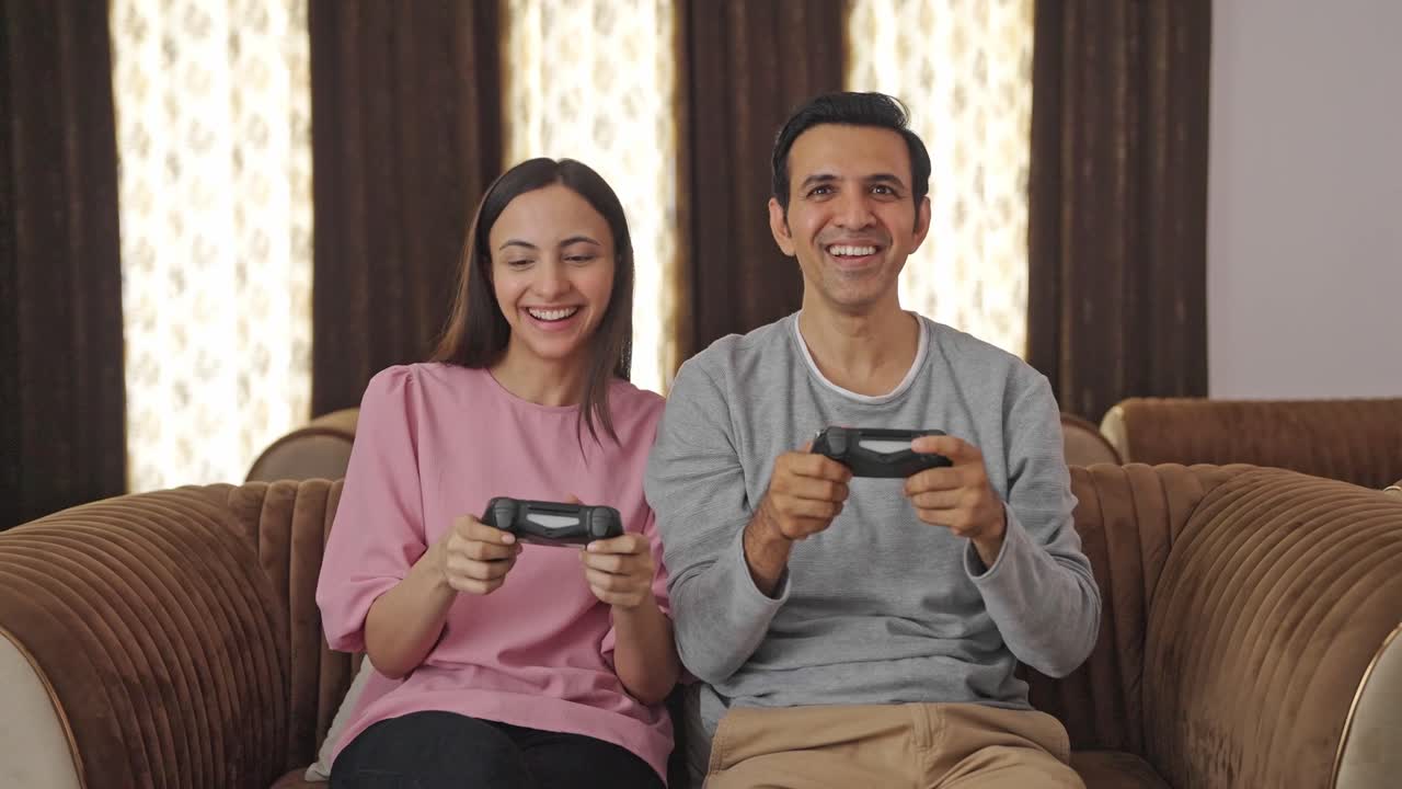 pareja india feliz jugando videojuegos