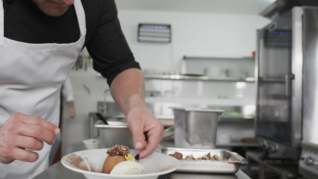 Chef maschio caucasico che decora un dessert in cucina, al rallentatore.