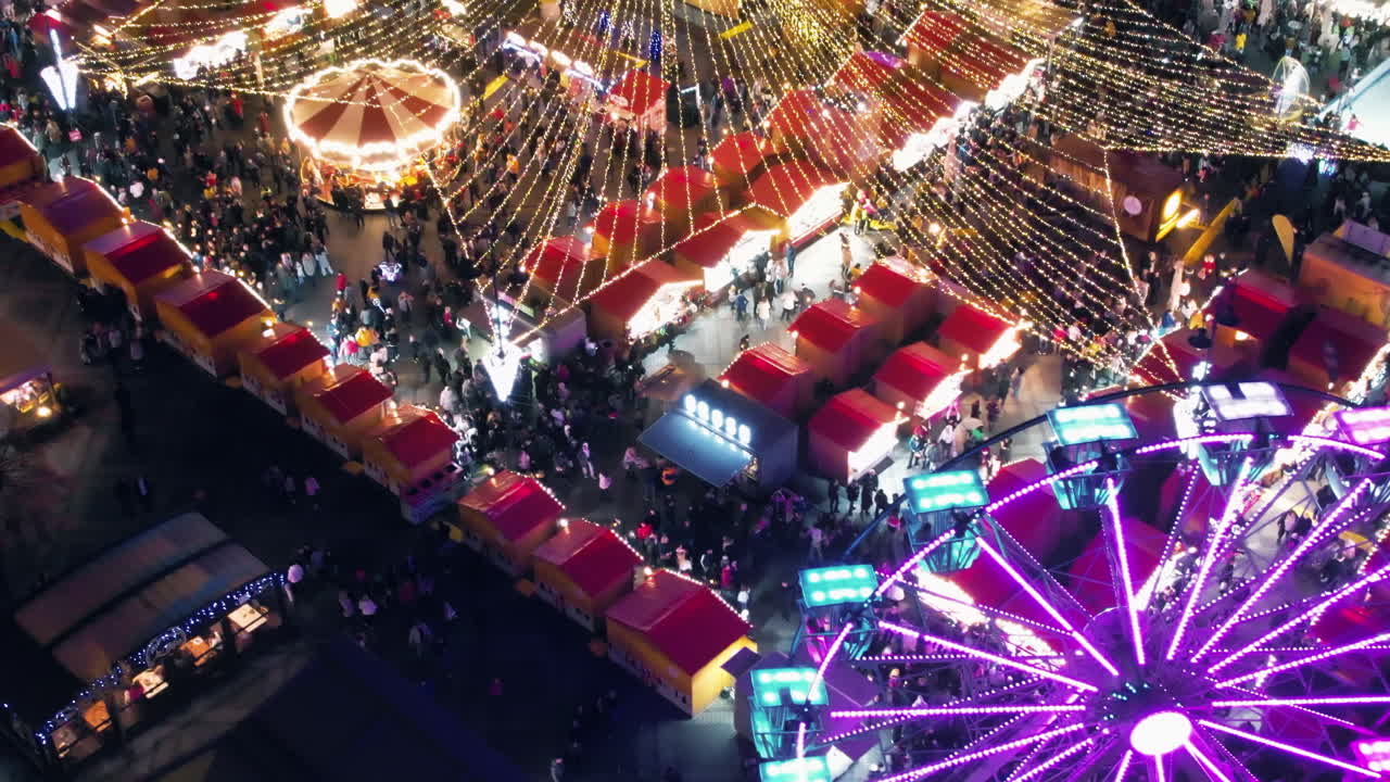 View of the Historic Centre of Sibiu with Christmas fair, Romania. The Great Square decorated with ferris wheel, Christmas tree, ice rink, illumination, old buildings and multiple people