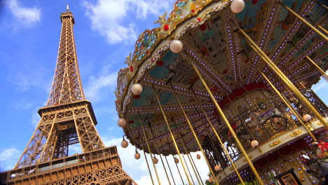 the eiffel tower rises behind a merry go round in paris france