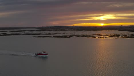 sunset over a river with a boat