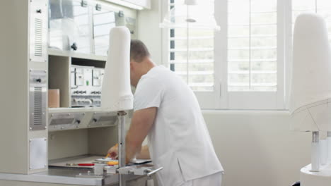 technician in prosthetic lab working on artificial limb, adjusting components