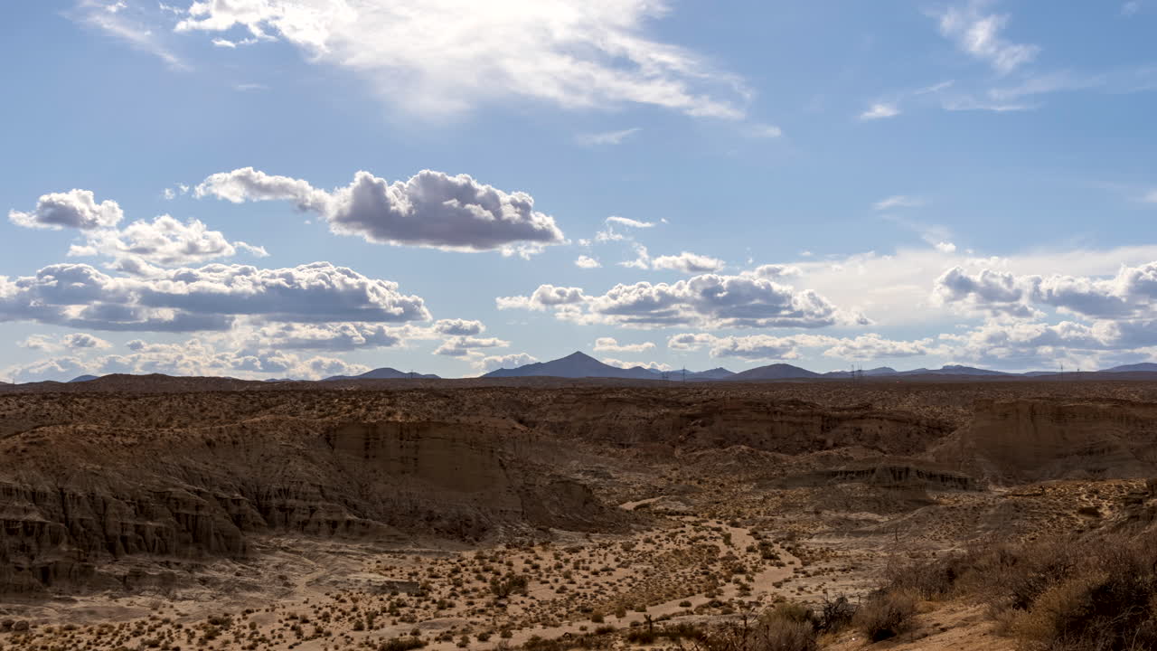 nubes que proyectan sombras sobre el cañón de roca roja ruedan por el cielo sobre el paisaje del desierto de mojave - lapso de tiempo estático
