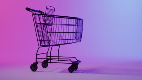 Un-Carrito-De-Compras-Se-Recorta-Sobre-Un-Fondo-Degradado-Púrpura-Y-Rosa,-Con-Espacio-Para-Copiar