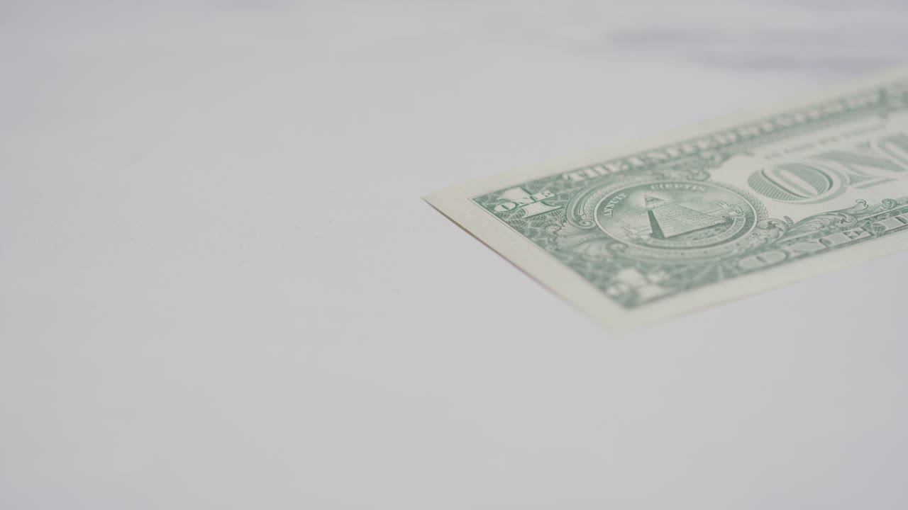 primer plano de moneda de la mano agarrando un billete de 1 dólar estadounidense sobre fondo de mármol 1