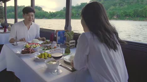 couple enjoying a romantic dinner on a river cruise