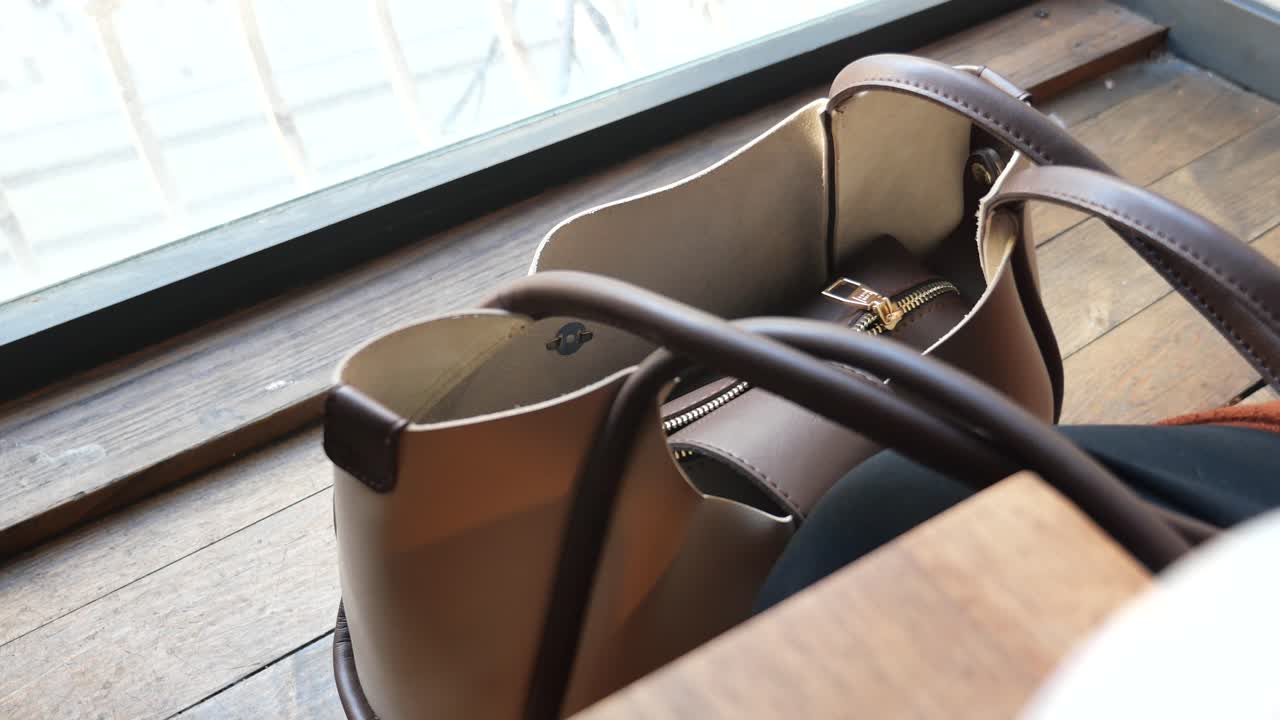 Woman retrieving phone from purse in cafe