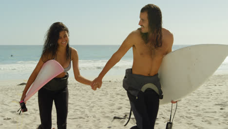 Pareja-Con-Tabla-De-Surf-Caminando-Por-La-Playa-4k-4k