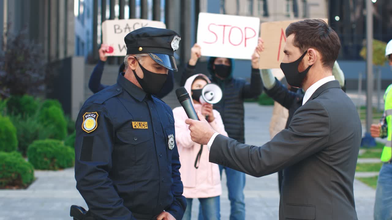 코비드 19에 항의하는 경찰관과의 인터뷰에서 보호 마스크를 쓴 백인 언론인이나 특파원