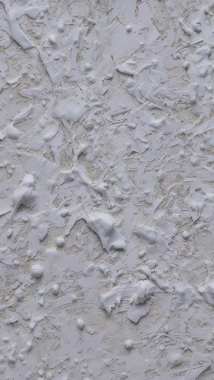 Vertical video: Shifting camera revealing white skimcoat on room wall, showing trowel marks, ridges